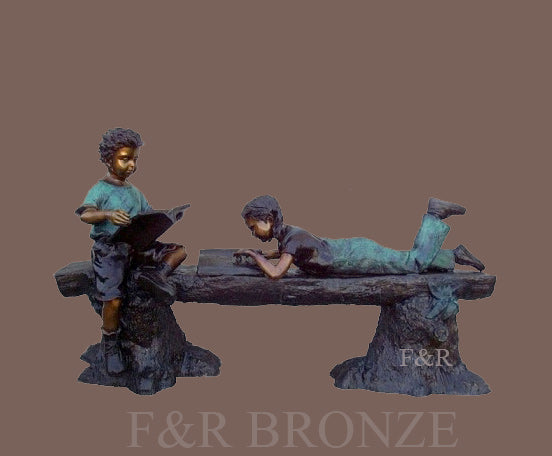 Front view of the Reading Time children bronze statue, showing two readers, the textured log and stump supports against a brown background.