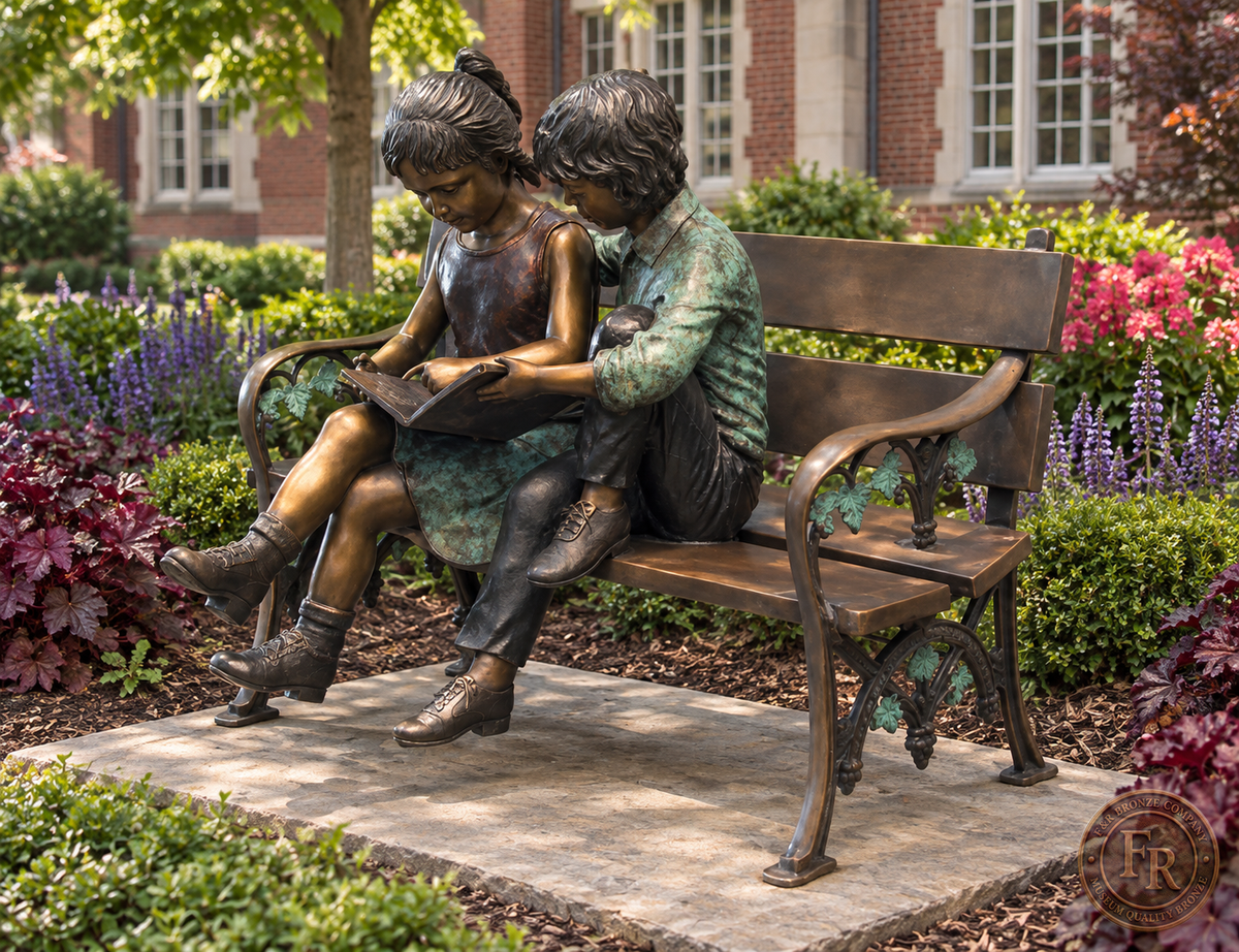 Three-quarter school courtyard concept of two kids on a bronze reading bench, showing the curved armrest and colored patina.