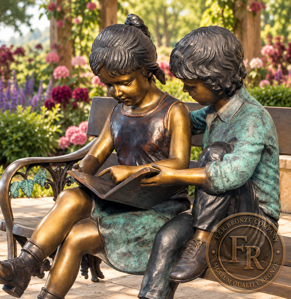 Garden concept close-up of the bronze girl holding a book and the boy leaning beside her, with green and warm brown patina.