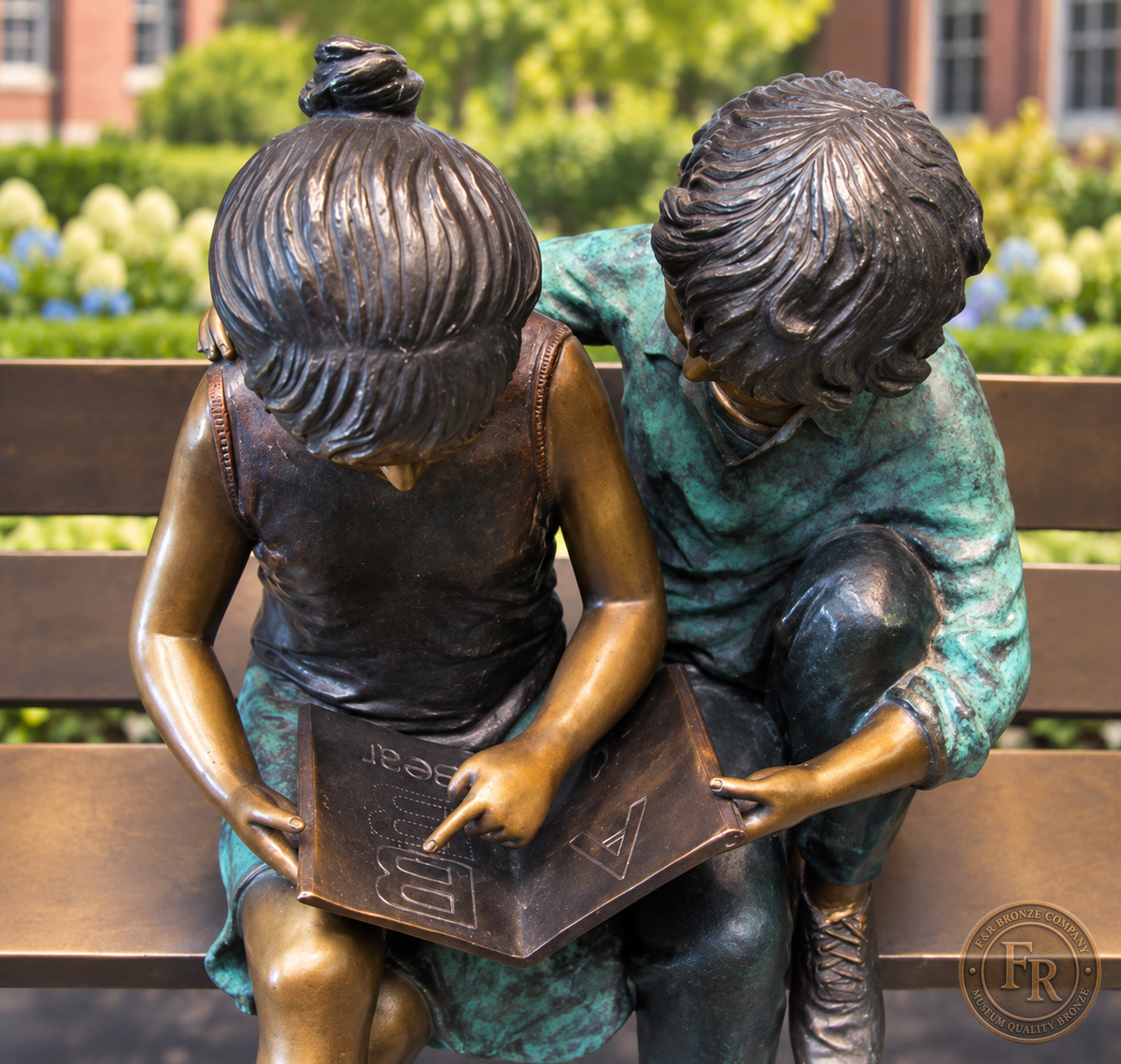 School garden concept viewed from above, showing the bronze children’s hands and open book with multicolor clothing.