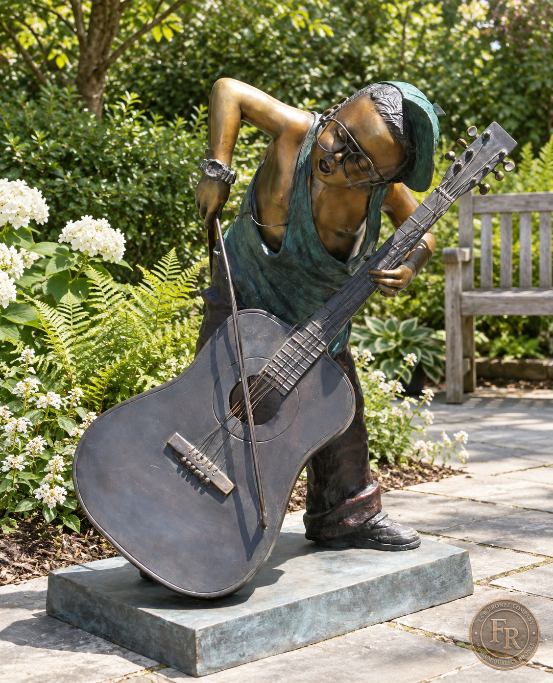 Jumbo Boy Playing Guitar Bronze Statue, item 806, front three quarter, in a modest garden setting. Placement concept based on the owner-supplied product photograph.