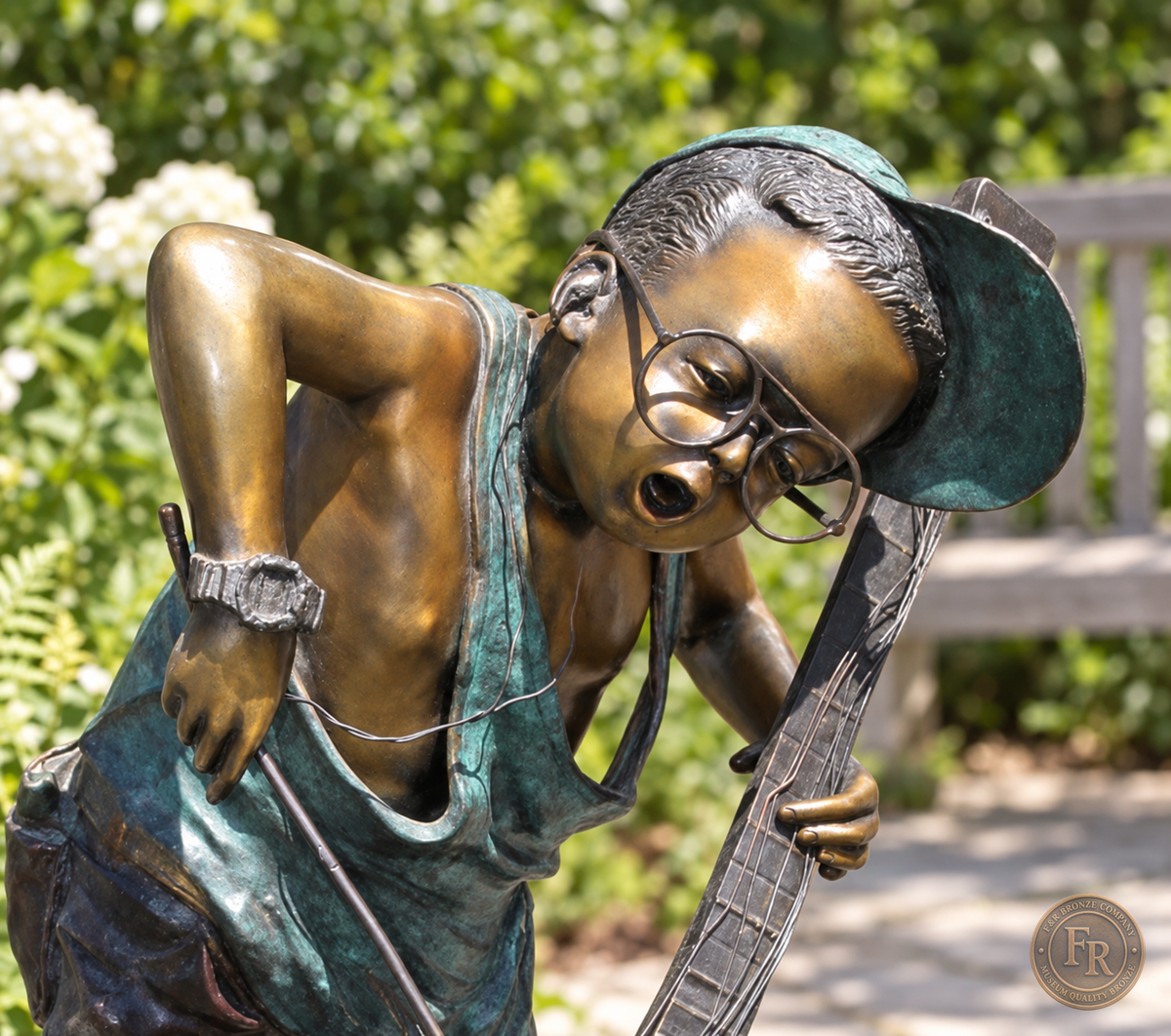 Jumbo Boy Playing Guitar Bronze Statue, item 806, face detail, in a modest garden setting. Placement concept based on the owner-supplied product photograph.