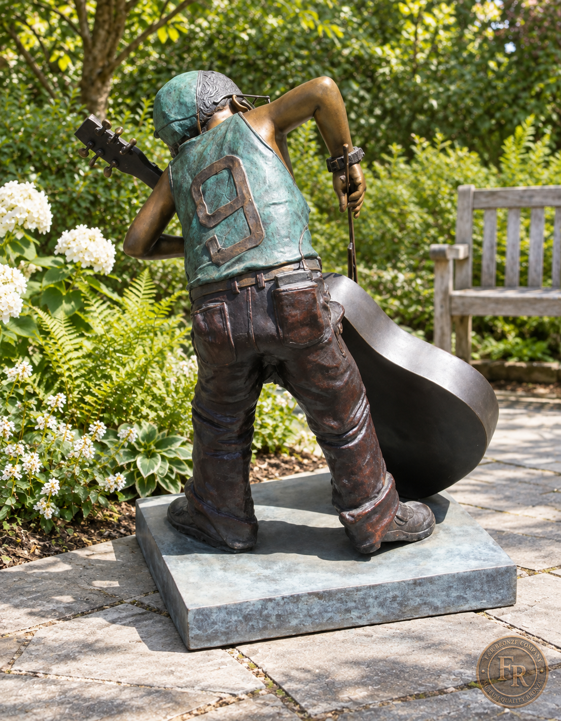 Jumbo Boy Playing Guitar Bronze Statue, item 806, rear full, in a modest garden setting. Placement concept based on the owner-supplied product photograph.