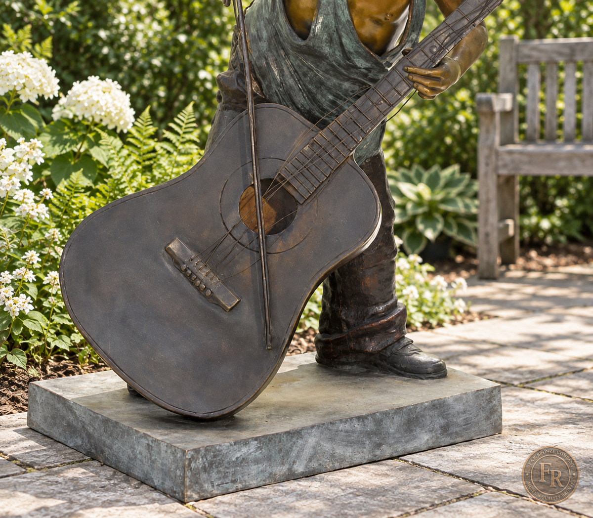 Jumbo Boy Playing Guitar Bronze Statue, item 806, instrument base detail, in a modest garden setting. Placement concept based on the owner-supplied product photograph.