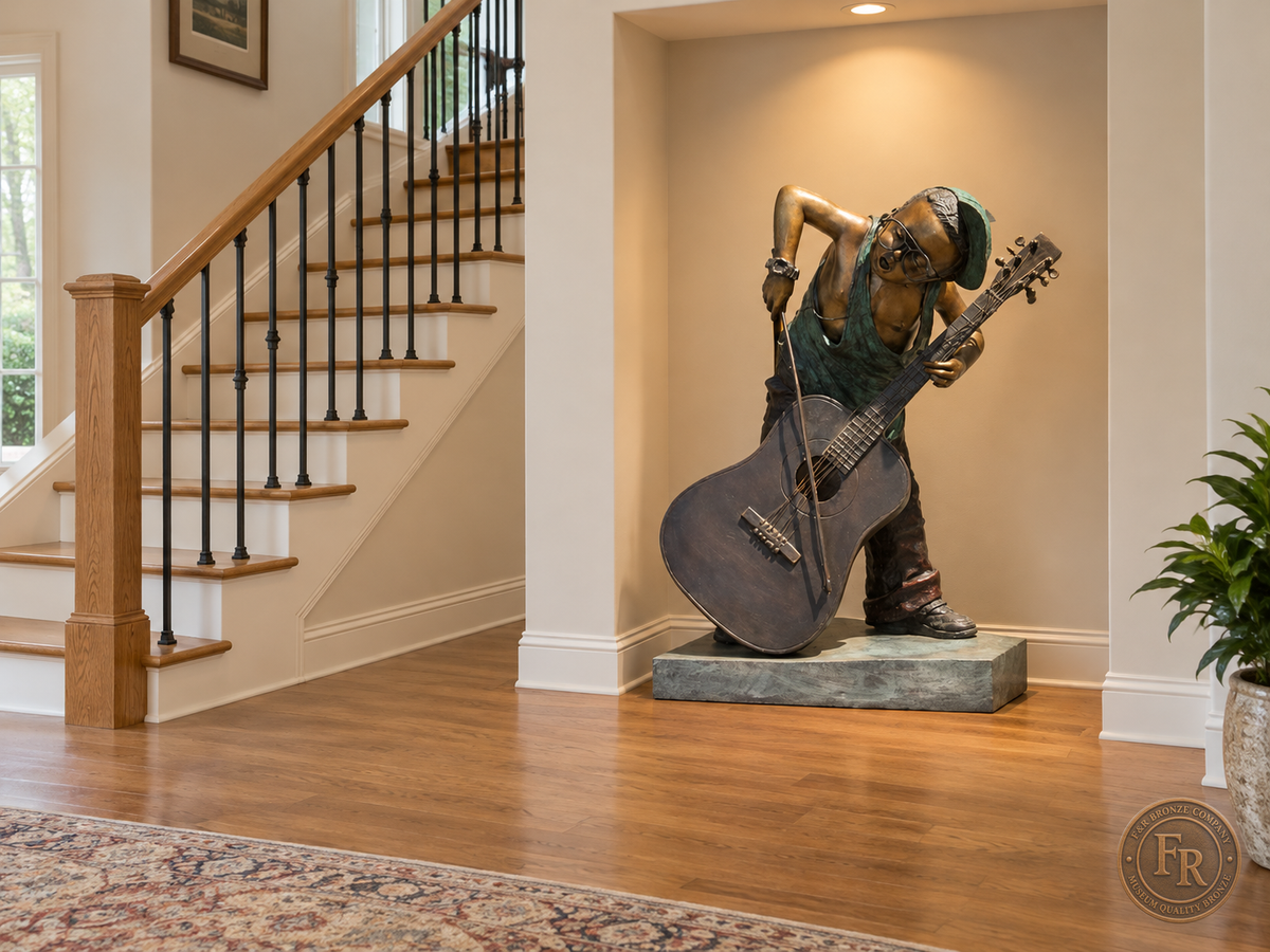 Boy musician bronze sculpture, front three-quarter view, placed in a wall display recess beside stairs with its original base and clear walking space.