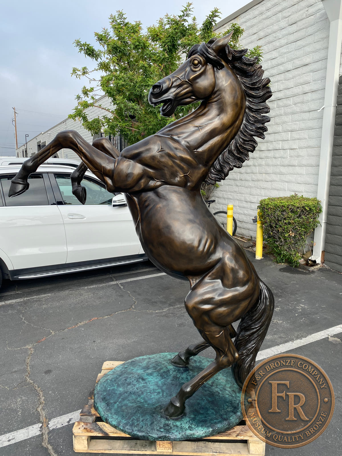Three-quarter product photograph of the life-size horse sculpture, showing its bronze body and raised forelegs.