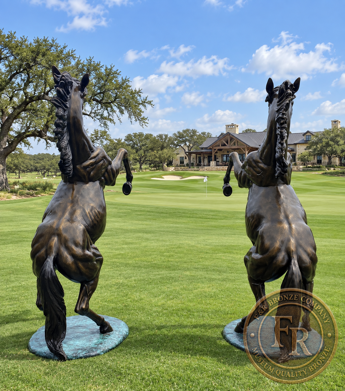 Rear view of two rearing horse bronzes showing their flowing tails in a landscape concept.
