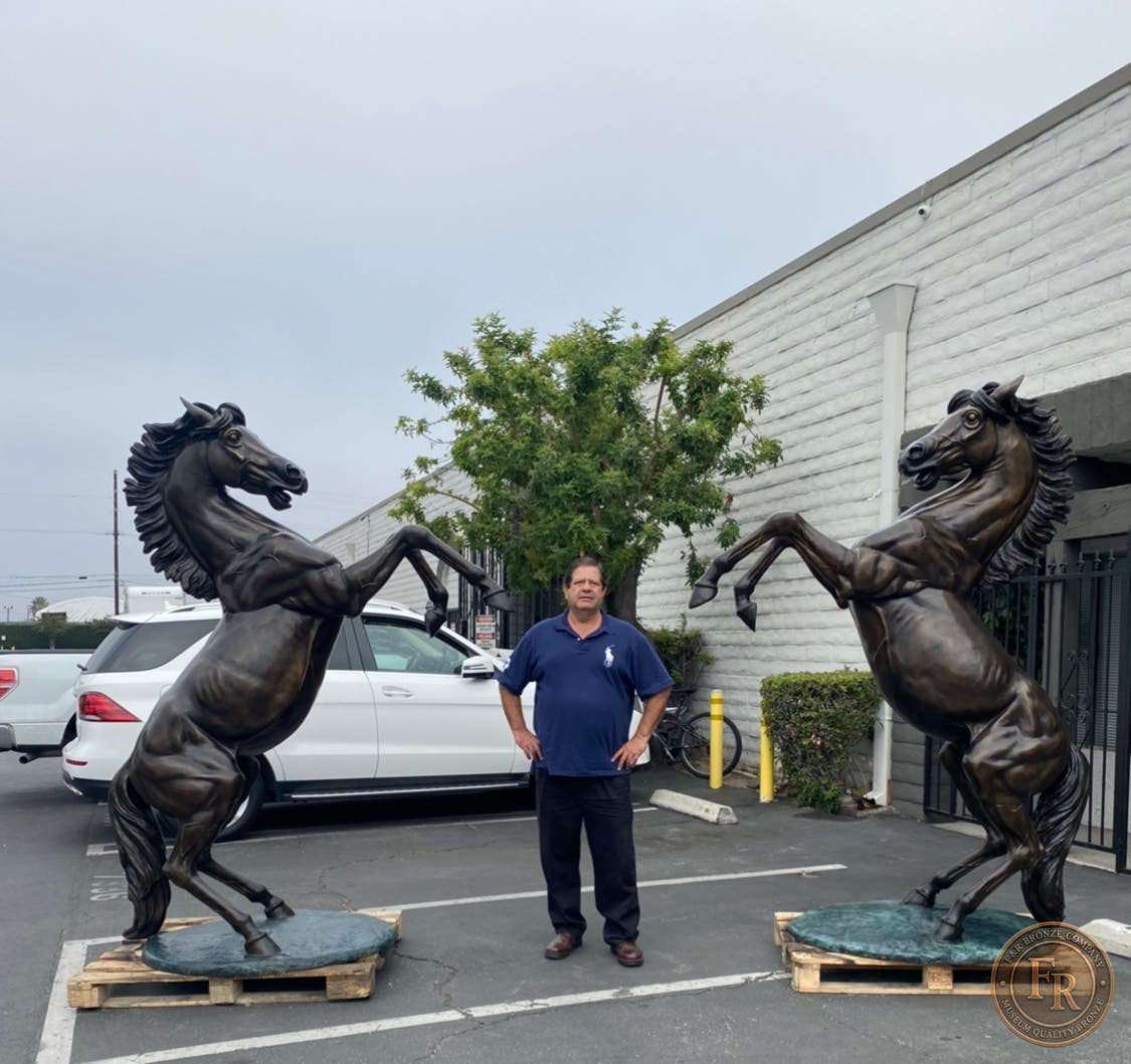 Front product photograph of the Right and Left stallion bronze statues on their oval green bases.