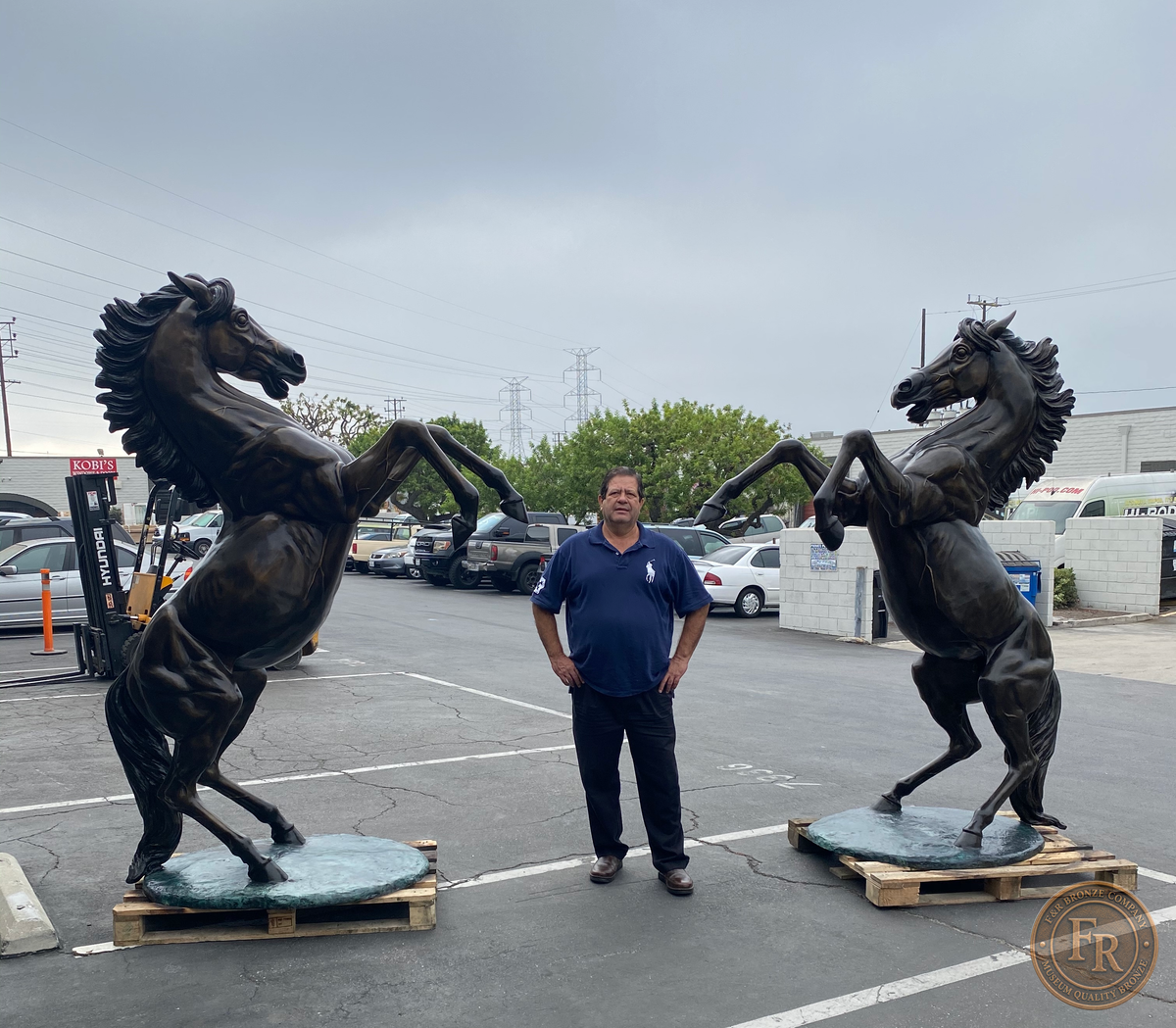 Original photograph of paired rearing bronze horses with Mike standing between them, front view.