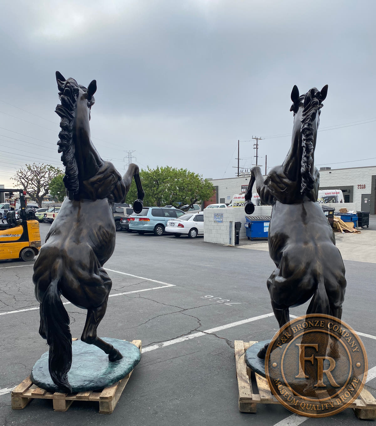 Original rear photograph of the rearing horse bronze set, showing both tails and oval bases.