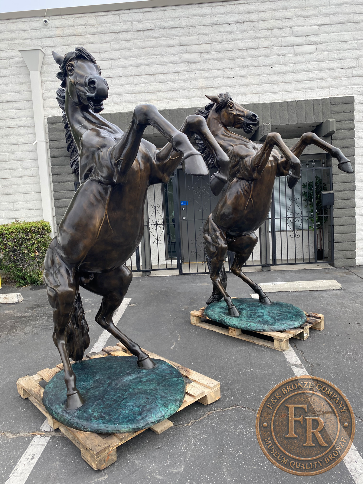 Two life-size bronze horses viewed at a front angle in an original product photograph.