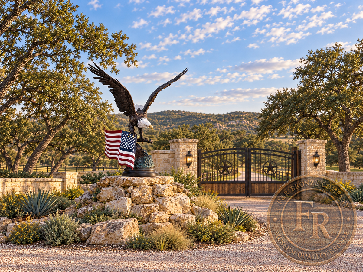 Eagle with American flag bronze sculpture above a stone foundation beside Texas ranch gates, architectural concept.