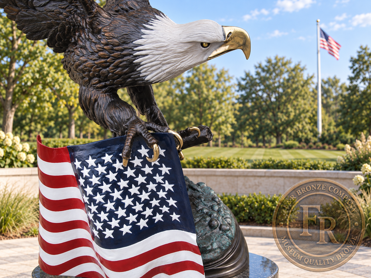 Close-up of the bronze bald eagle’s painted white head, golden-toned talons and American flag in a veterans memorial concept.