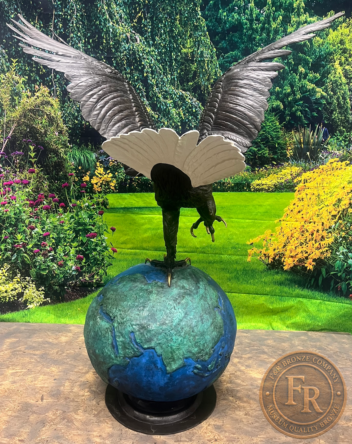 Original rear photograph of the Monumental Eagle on Globe bronze statue, showing spread wings, a white tail and blue-green globe.