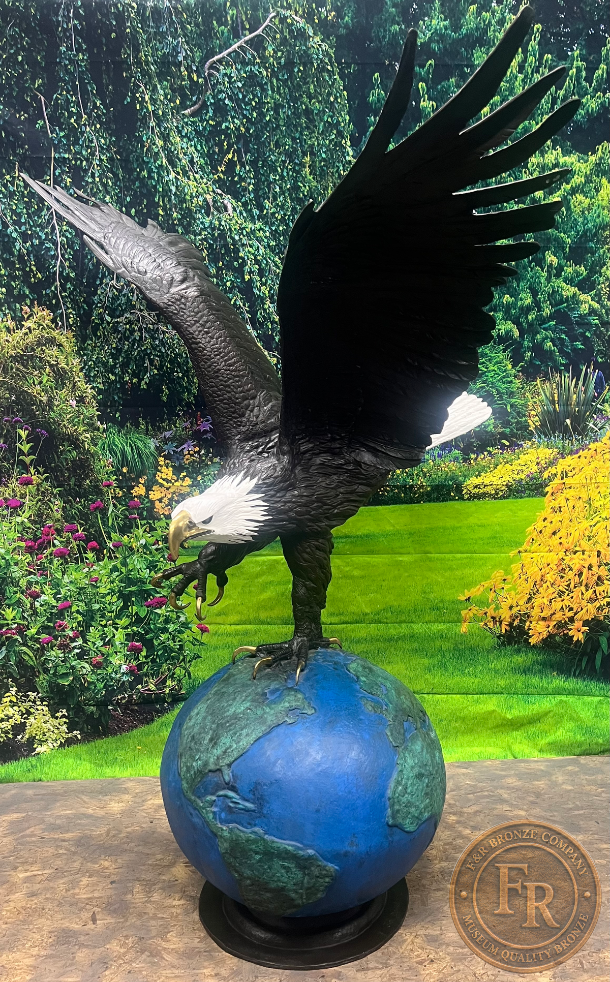 Original three-quarter product photograph of the Monumental Eagle on Globe bronze statue, showing the complete eagle, blue-green globe and round base.