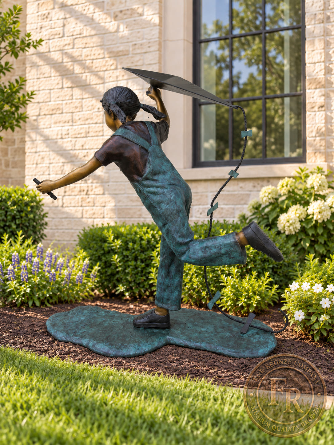 Side view of the little girl running with a kite bronze statue, showing her extended arm, overalls and lifted foot.