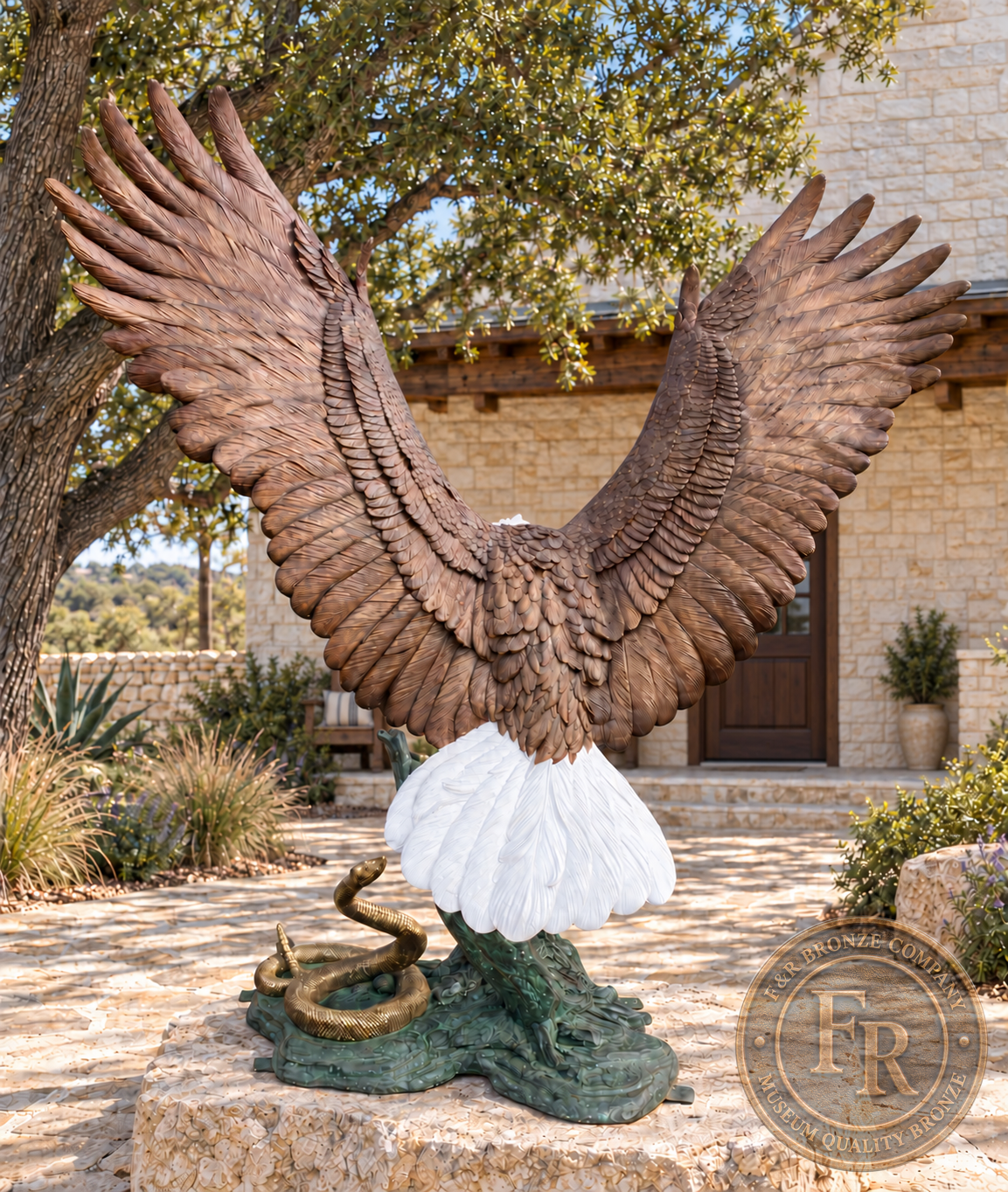 Rear view of the heroic eagle bronze sculpture, with layered wing feathers, a white tail and the rattlesnake beside its green base.