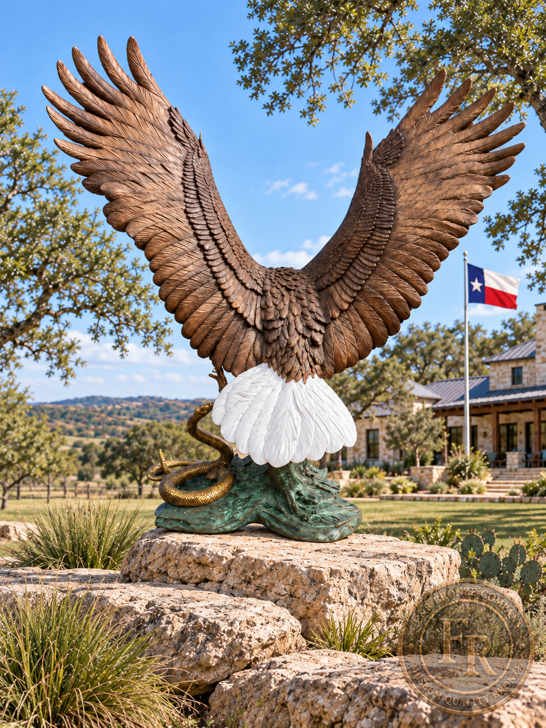 Rear view of the monumental eagle bronze sculpture on a ranch rock platform, showing spread wings, white tail and the snake at its base.