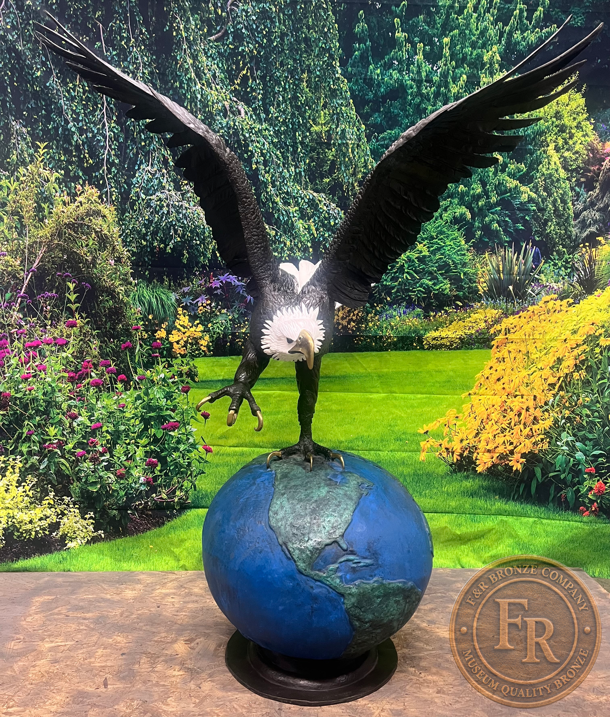 Original front photograph of the eagle on globe bronze sculpture, showing raised wings and one extended claw above the globe.